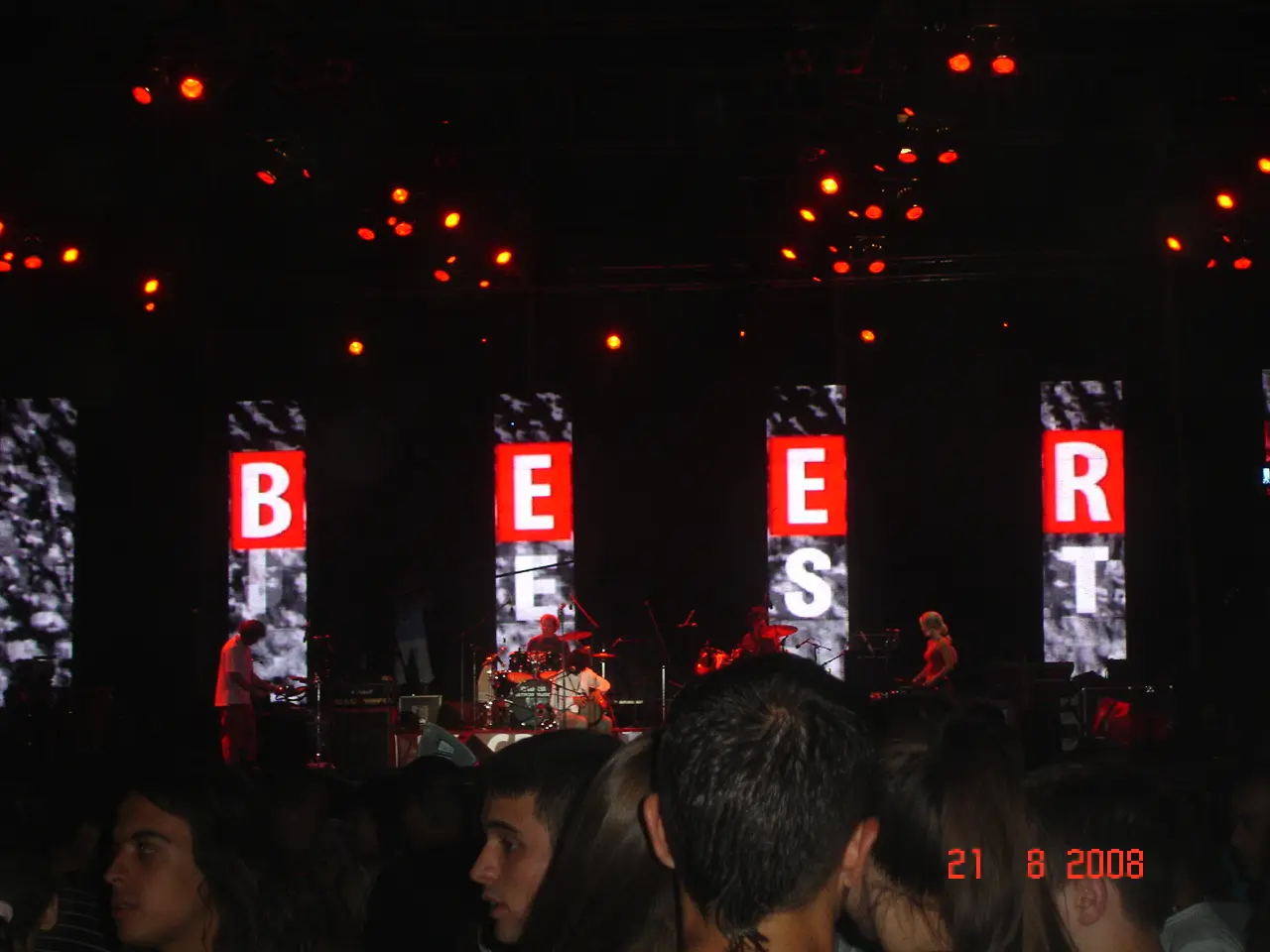 A large illuminated BEER FEST sign above the main stage with a band performing at night