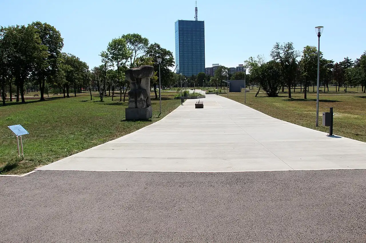 Ušće park on an ordinary summer day, a tree-lined path leading toward the glass Ušće Tower in New Belgrade