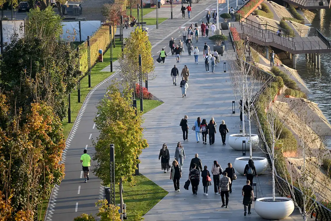 People walking the wide riverside promenade beside Savski park on the Sava in Belgrade