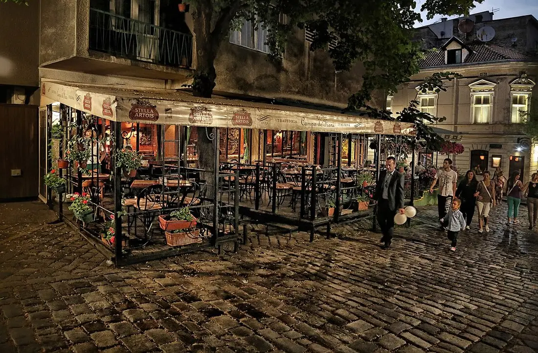 Belgrade old-town streets lit up at night with bar fronts and passing traffic
