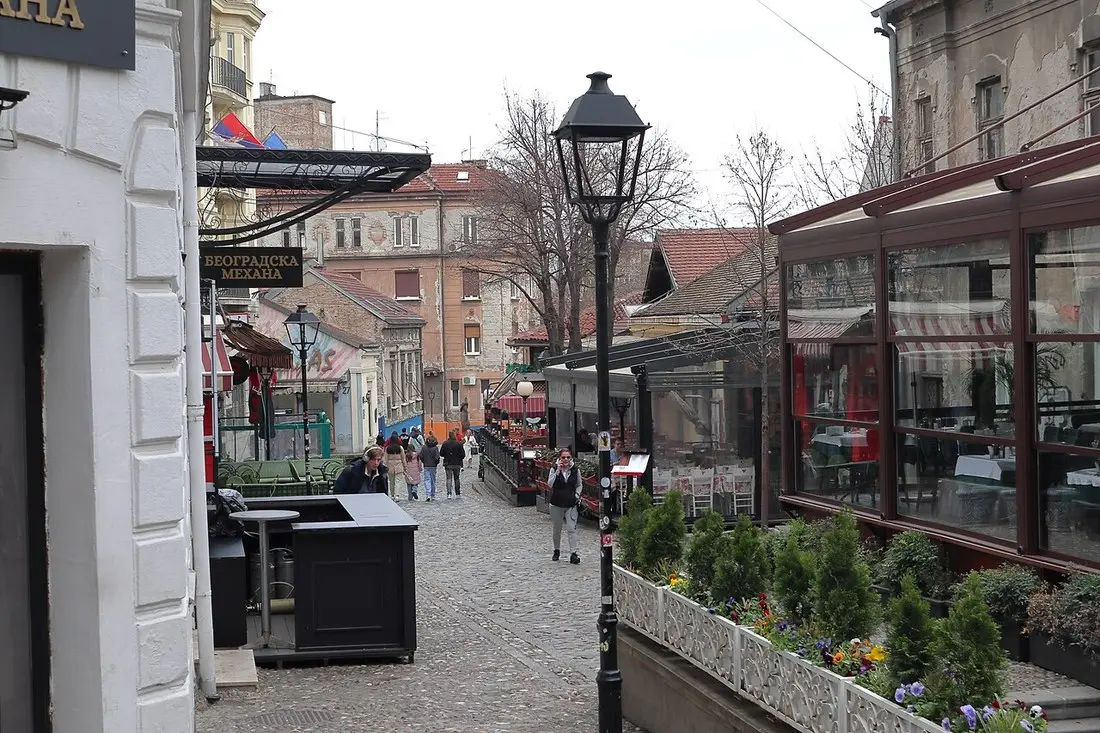 The cobbled Skadarlija lane in Belgrade on a quiet afternoon, kafana facades and outdoor seating