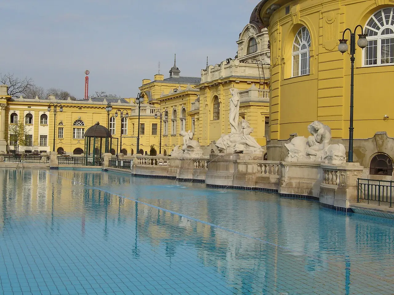 The yellow baroque facade and outdoor pool of the Szechenyi thermal bath in Budapest