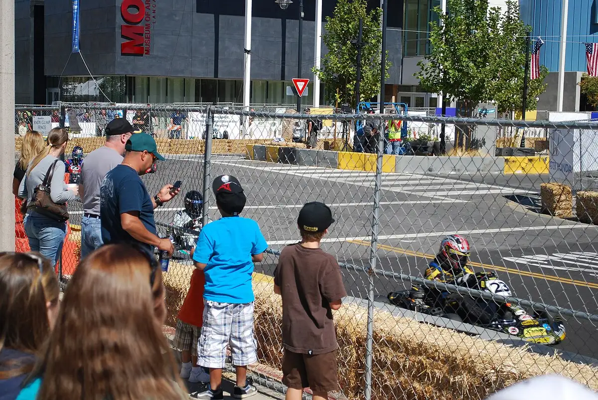 Go-karts racing on a paved outdoor circuit with barriers and timed laps