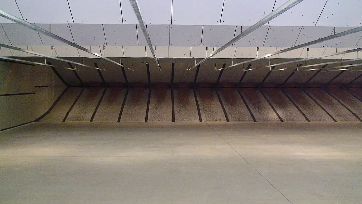 An indoor firing range with lanes, target boards and a protected shooting position