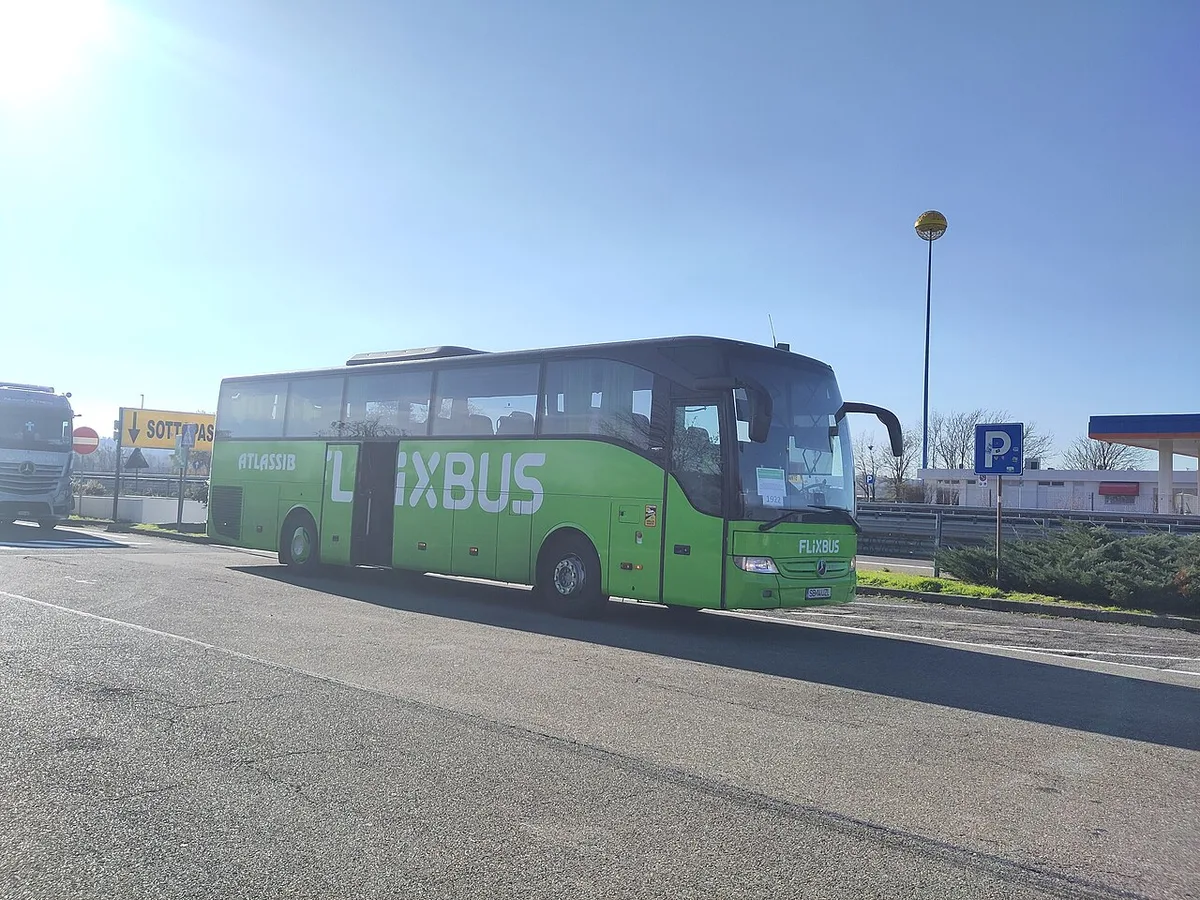 A green FlixBus long-distance coach at a roadside stop, the type that runs the Belgrade to Budapest route