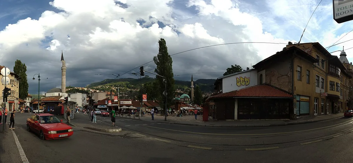 Panorama of Sarajevo old town, Baščaršija, with minarets and red roofs under wooded hills