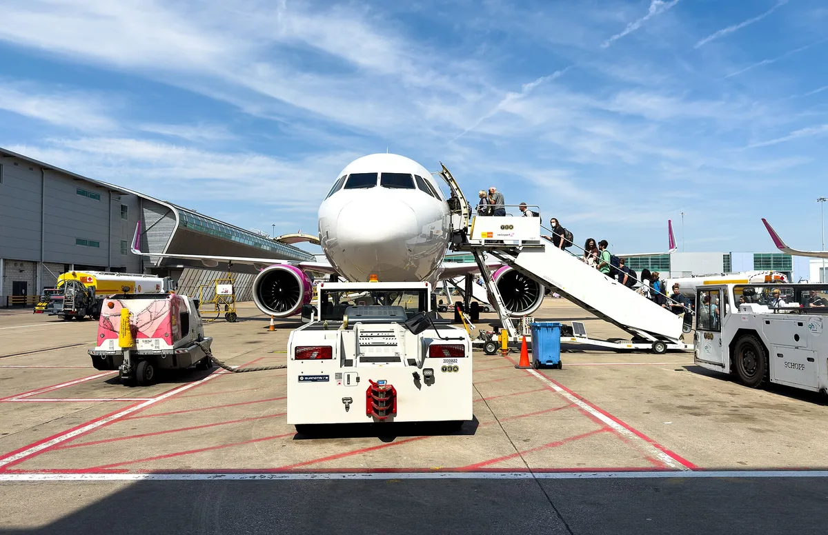 A Wizz Air Airbus A321neo in the airline pink-and-purple livery on the ground