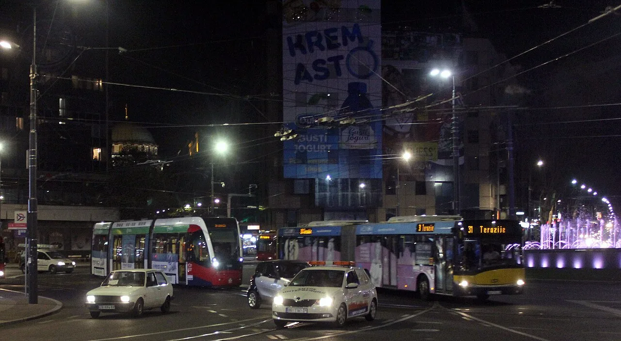 Trams and buses crossing the roundabout at Slavija Square in Belgrade at night