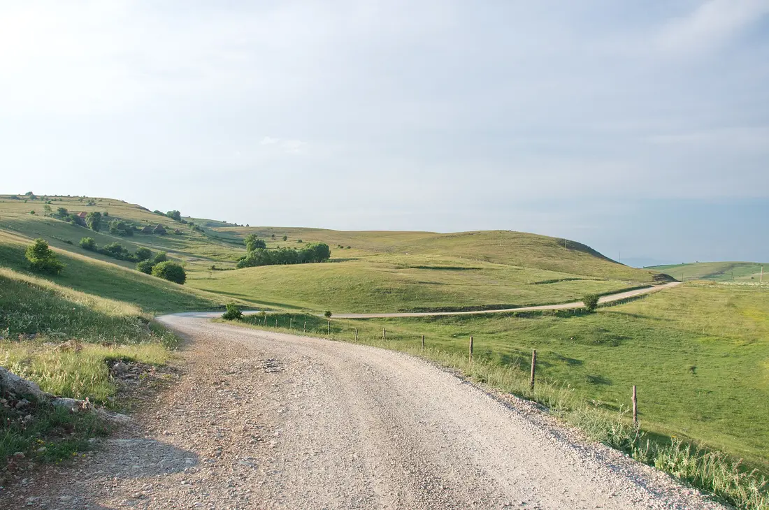 A winding road crossing a green mountain plateau in Serbia