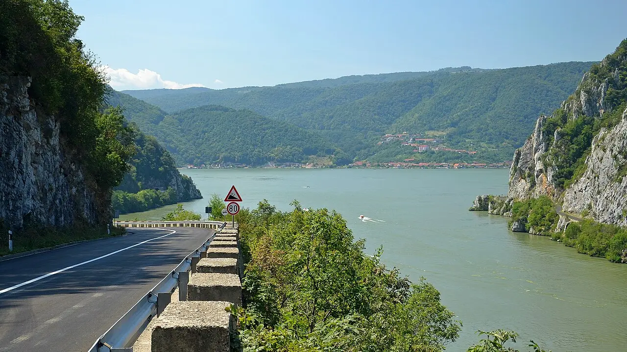 The two-lane Danube road running along a cliff above the green water of the Iron Gate gorge