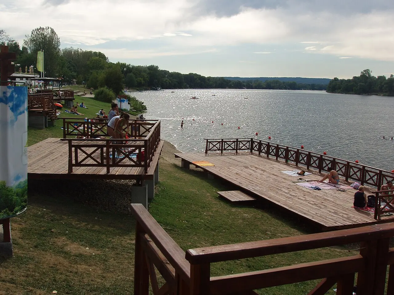 Wooden sun decks and swimmers along the shore of Silver Lake near Veliko Gradiste
