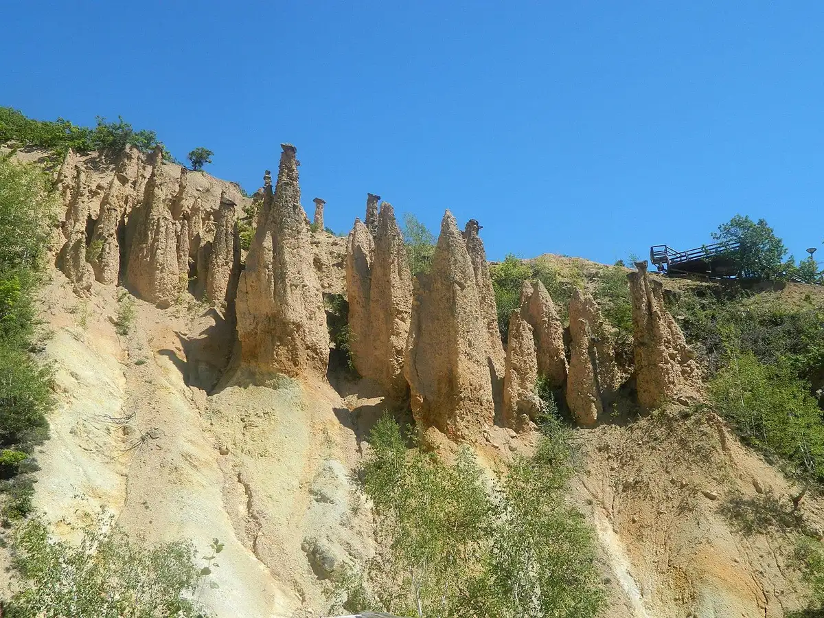 Đavolja Varoš seen from the cascades below, the pale towers strung up a wooded gully on Radan Mountain