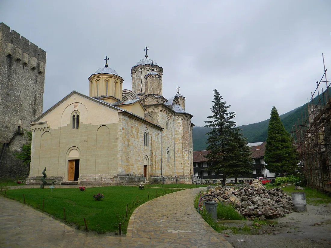 The domed Holy Trinity church of Manasija monastery beside a fortress tower and stone walls