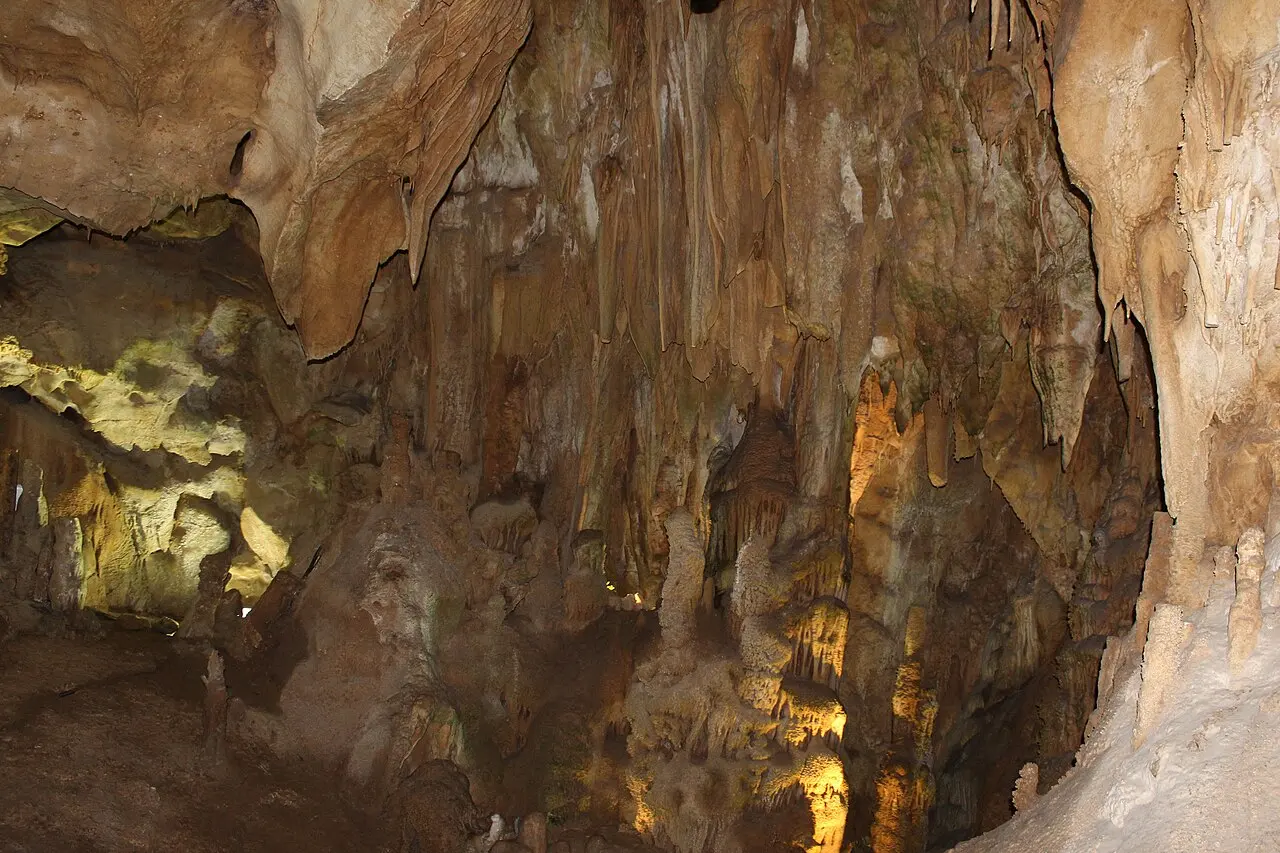 Warm-lit stalactites and stone drapery inside the chambers of Resava Cave