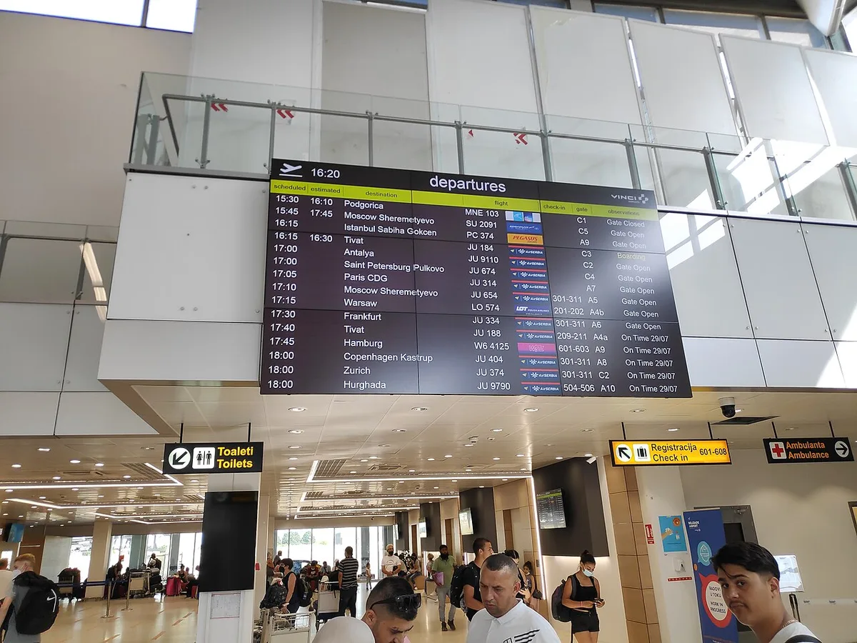 The departures hall of Belgrade Nikola Tesla Airport with check-in desks and passengers