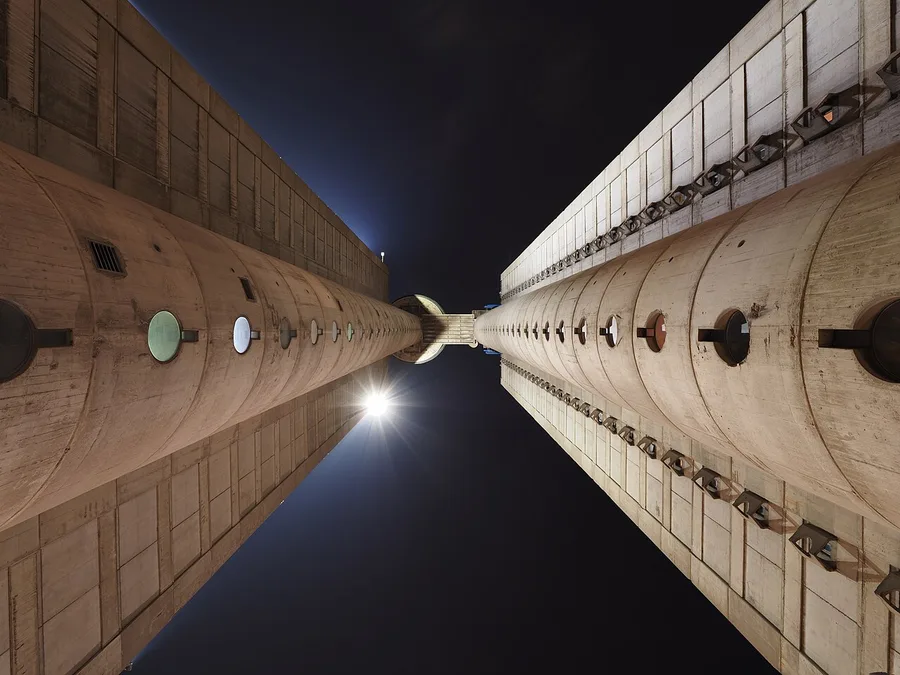 Looking up between the twin concrete towers of the brutalist Genex Tower (Western City Gate) in New Belgrade at night