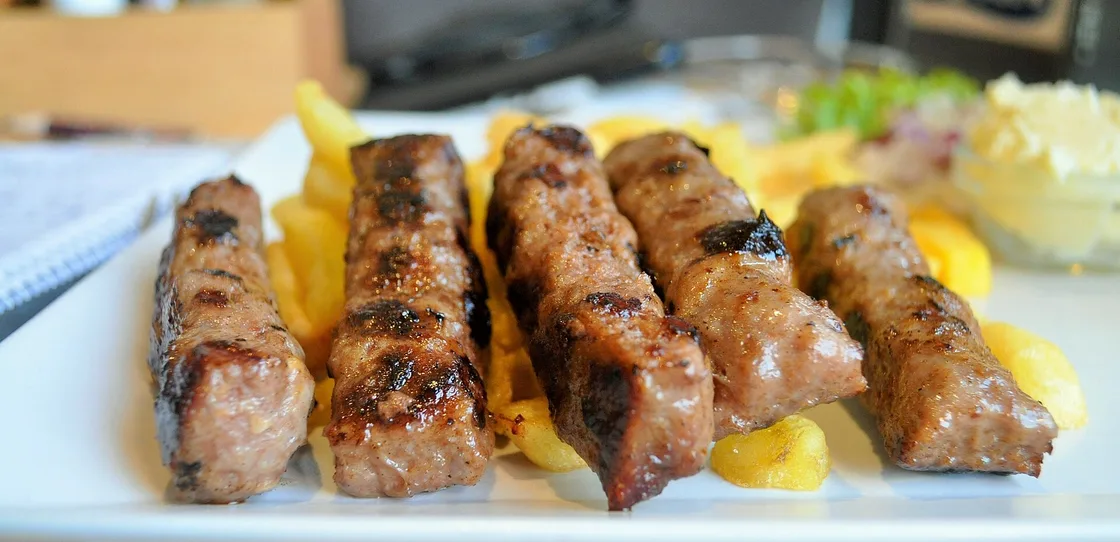 A plate of Serbian ćevapi, small grilled minced-meat rolls, with bread and onion