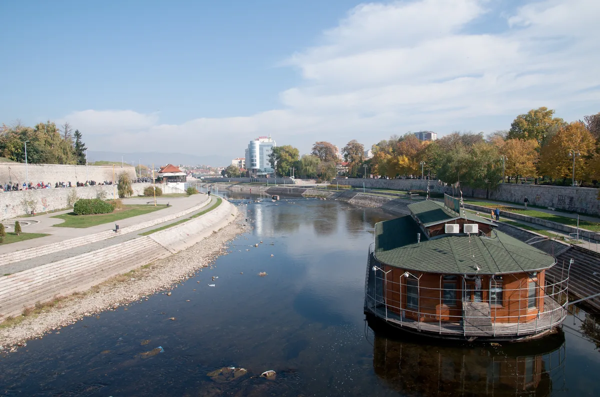 The Nišava river running through Niš with the fortress walls on the left bank, a riverside promenade and a floating café