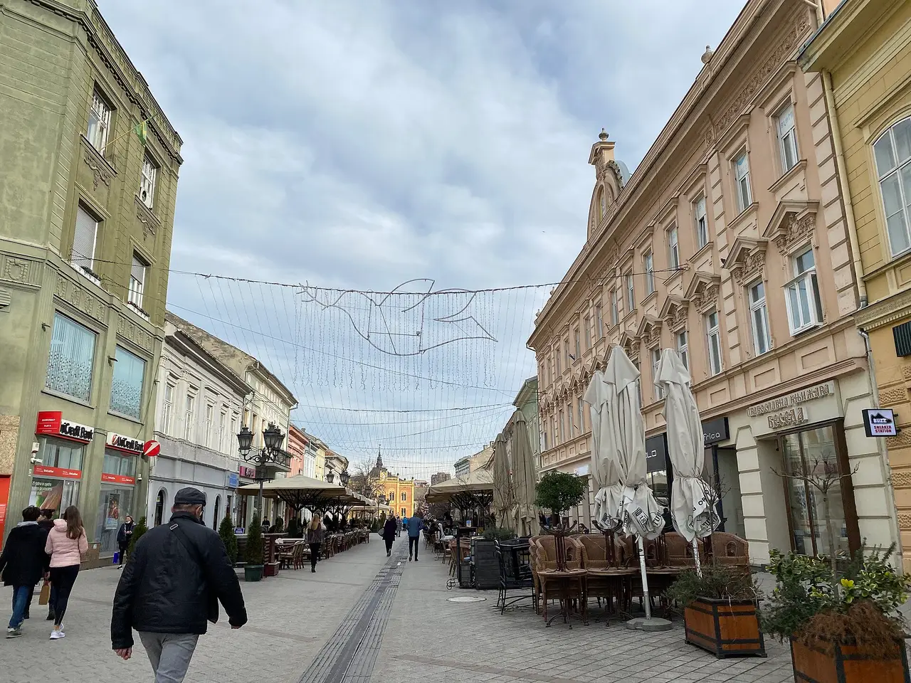 The pedestrian Zmaj Jovina Street in Novi Sad lined with low pastel buildings, cafés and strollers