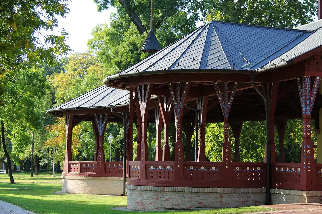 The open timber colonnade of the Grand Terrace at Palic painted deep red with blue and white folk ornament