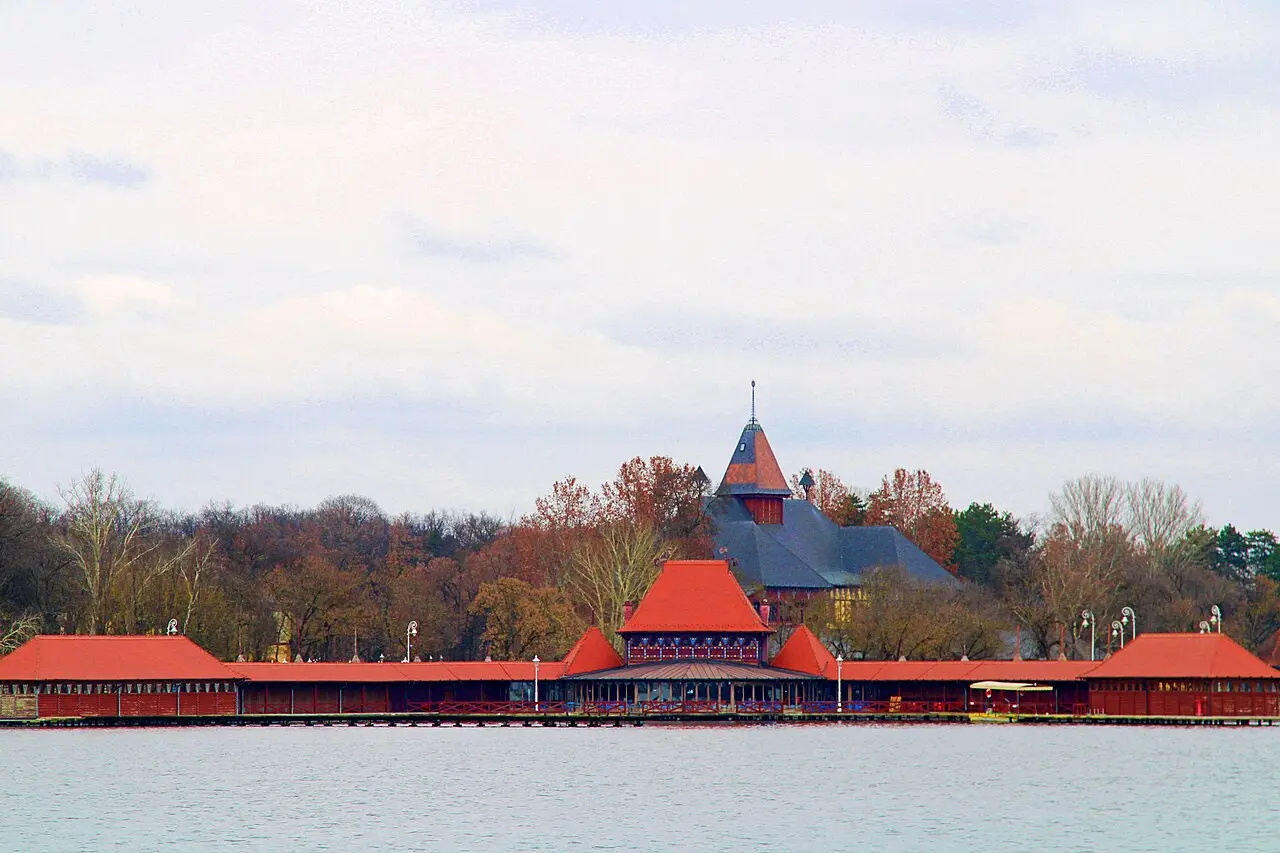 The long red timber Women's Lido pavilion standing on piles over Lake Palic, seen from the water