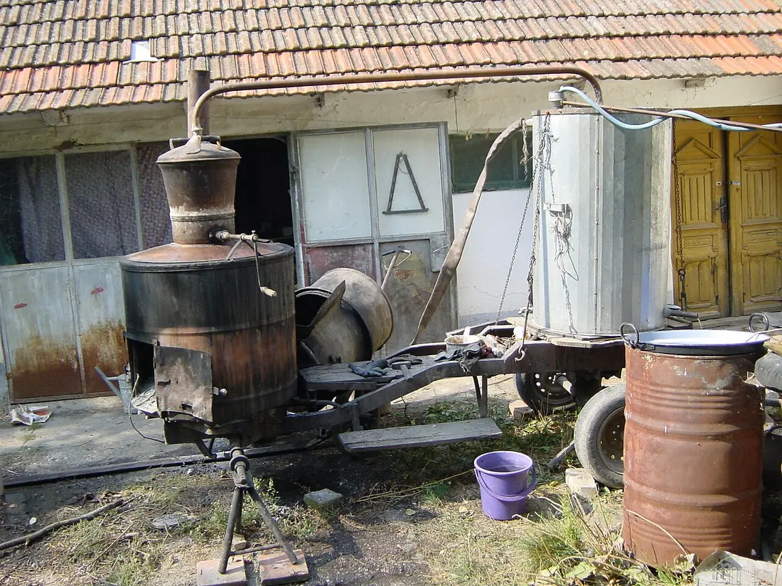A traditional copper still (kazan) set over a fire, used to distil homemade Serbian rakija