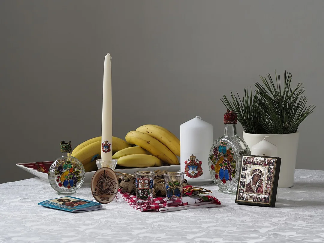 A laid Serbian festive table with food, bread and bottles, the setting where the first rakija is poured