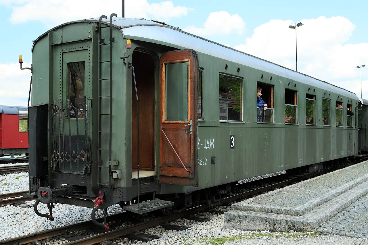 A vintage green passenger carriage of the Šargan Eight standing at Šargan-Vitasi station