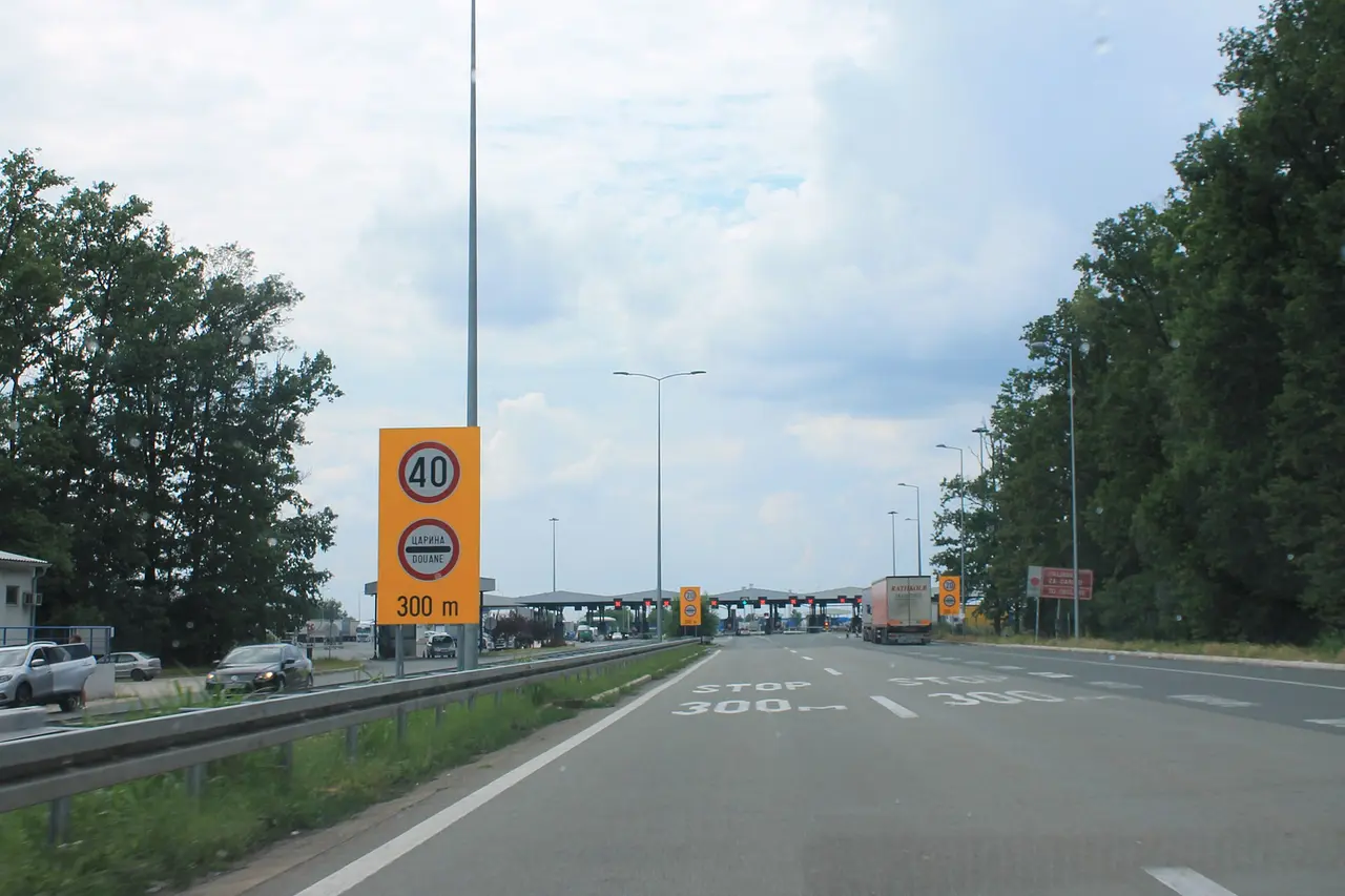 Motorway signs 300 metres before the Batrovci crossing showing a 40 km/h limit and the customs symbol
