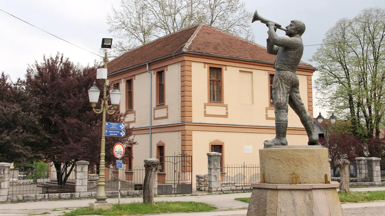 The bronze trumpeter statue standing in an empty square in the village of Guca on an out-of-season spring day