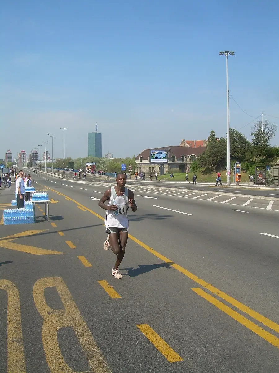 A lone runner on a completely empty Belgrade boulevard during the marathon, the Usce tower behind