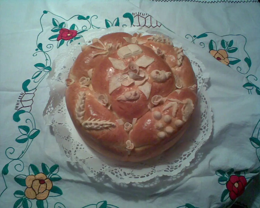 A decorated slava bread, the slavski kolac, resting on an embroidered white cloth
