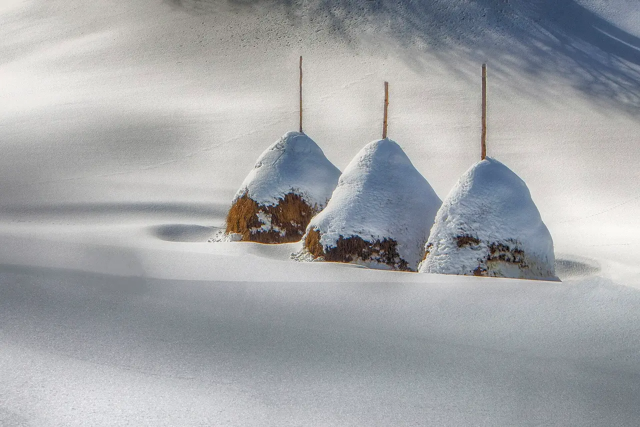 Three snow-capped haystacks standing in a deep, wind-sculpted snowfield near the Iver peak above Mokra Gora