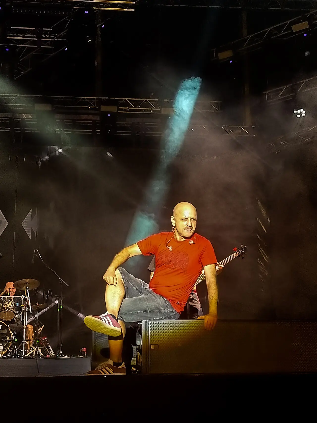 A bassist in a red shirt lit by a blue spotlight on the main stage of Belgrade Beer Fest