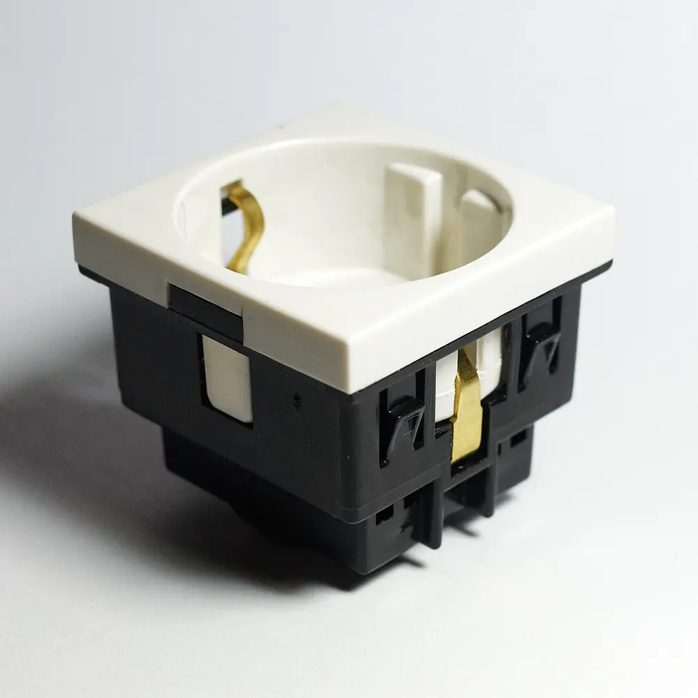 A white European Type F Schuko wall socket with two round pin holes and side earth clips