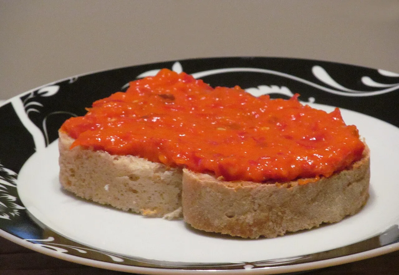 Deep-red ajvar, a roasted red pepper relish, in a jar and dish