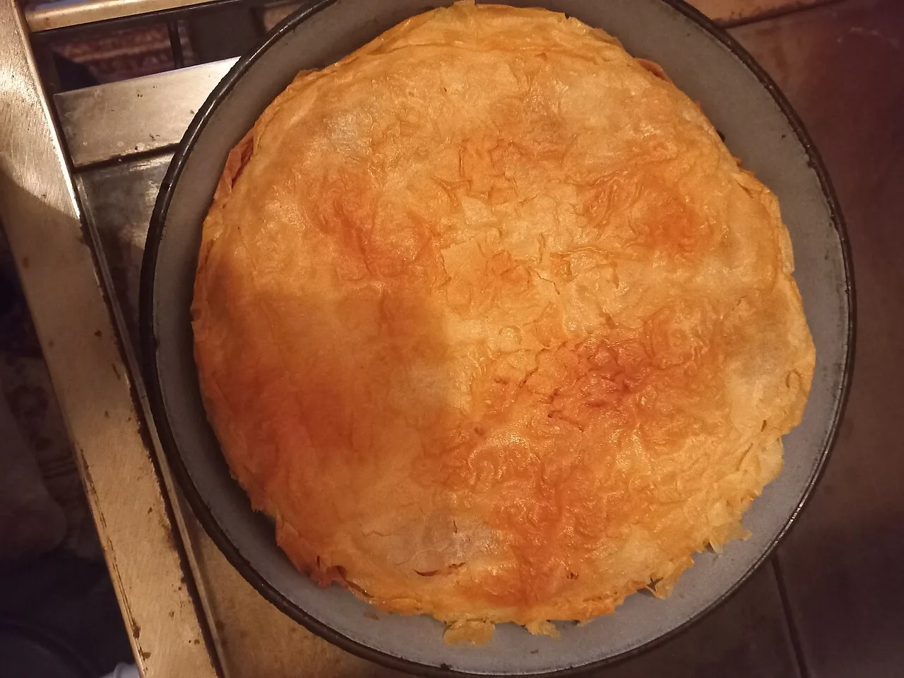 Baked gibanica, a layered filo and cheese pie, cut into portions
