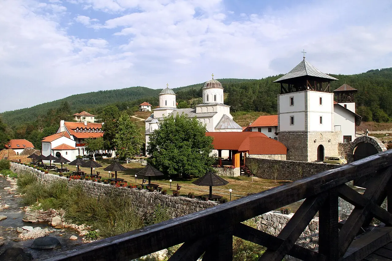The Mileseva monastery complex with its bell tower and white church in a green valley near Prijepolje