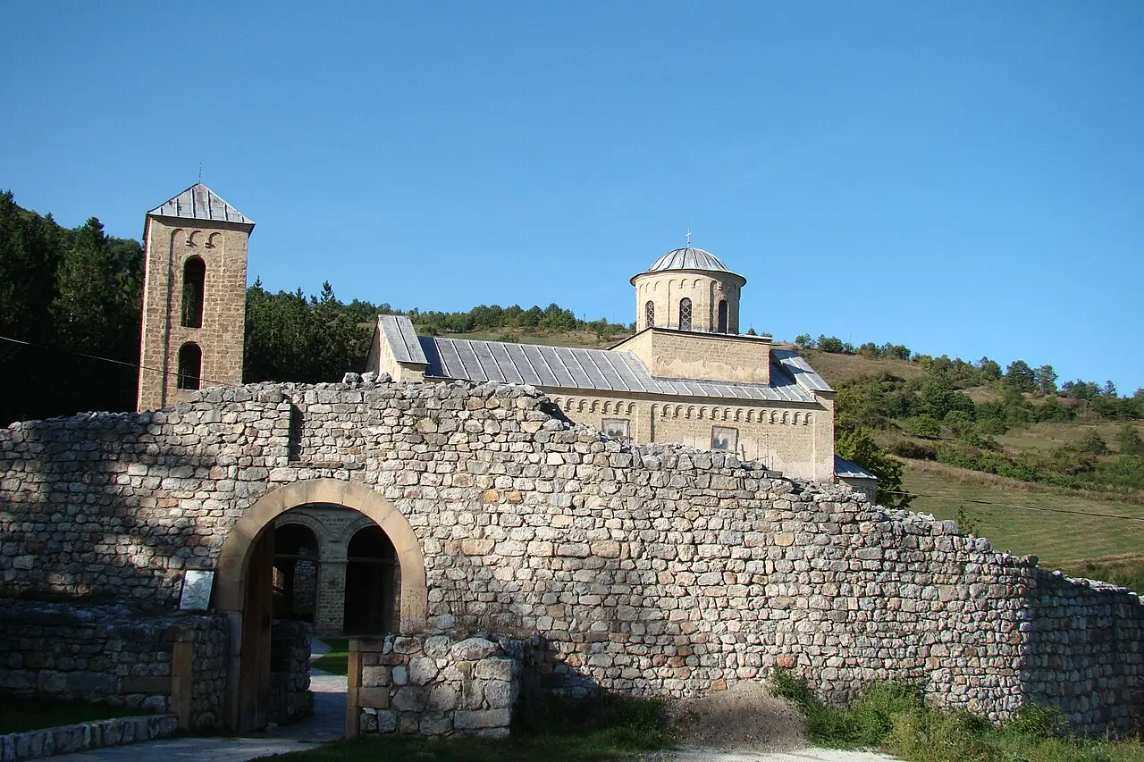 The stone church of Sopocani monastery behind its low ruined wall in the hills west of Novi Pazar