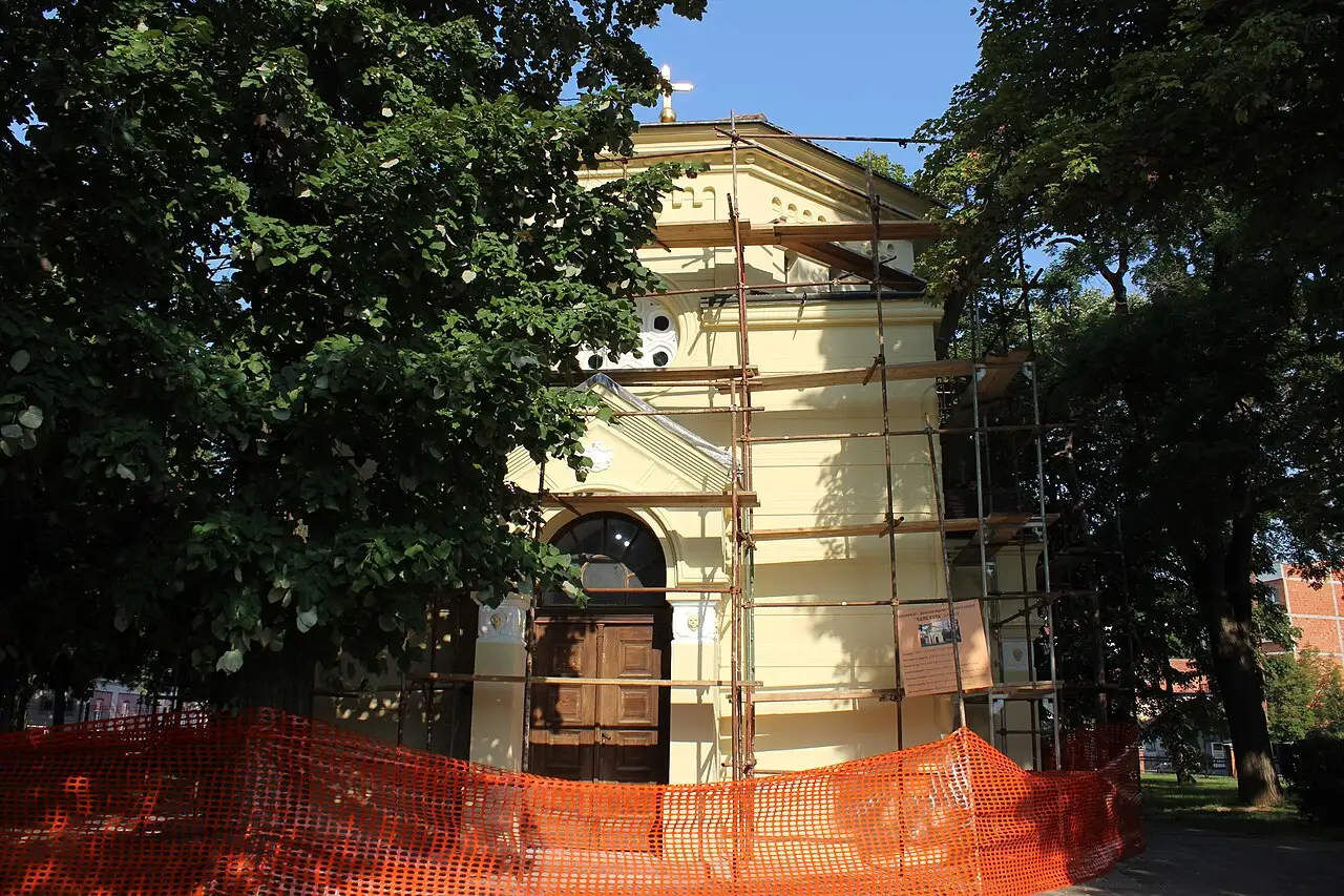 The Skull Tower chapel from the side, a small yellow stone building in a quiet park in Niš