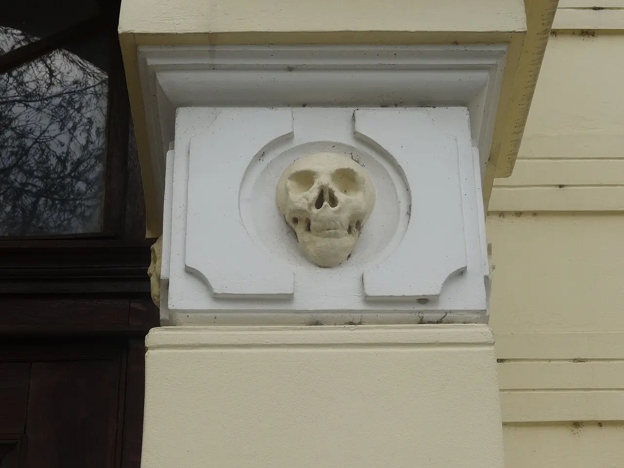 The dim interior of the Skull Tower chapel with the embedded skulls visible on the stone tower