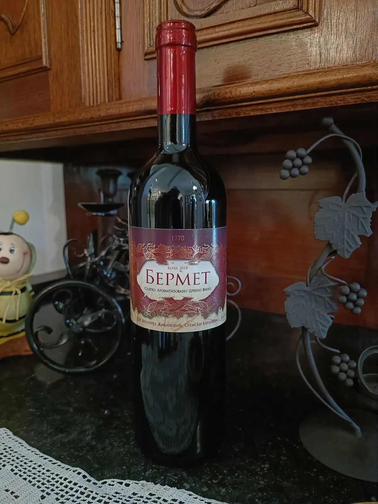 A bottle of red bermet from a Sremski Karlovci cellar standing on a dark counter