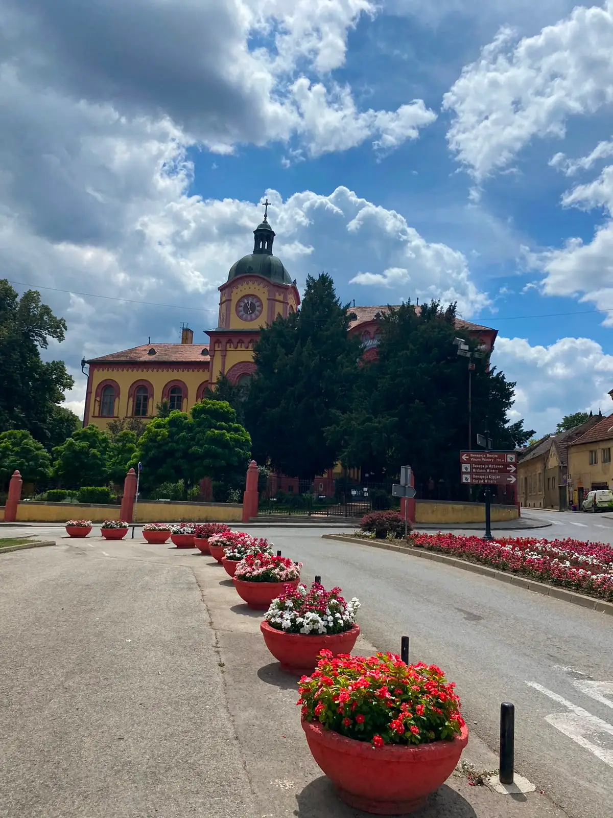 The yellow neo-Renaissance building of the Karlovci Grammar School seen from the square