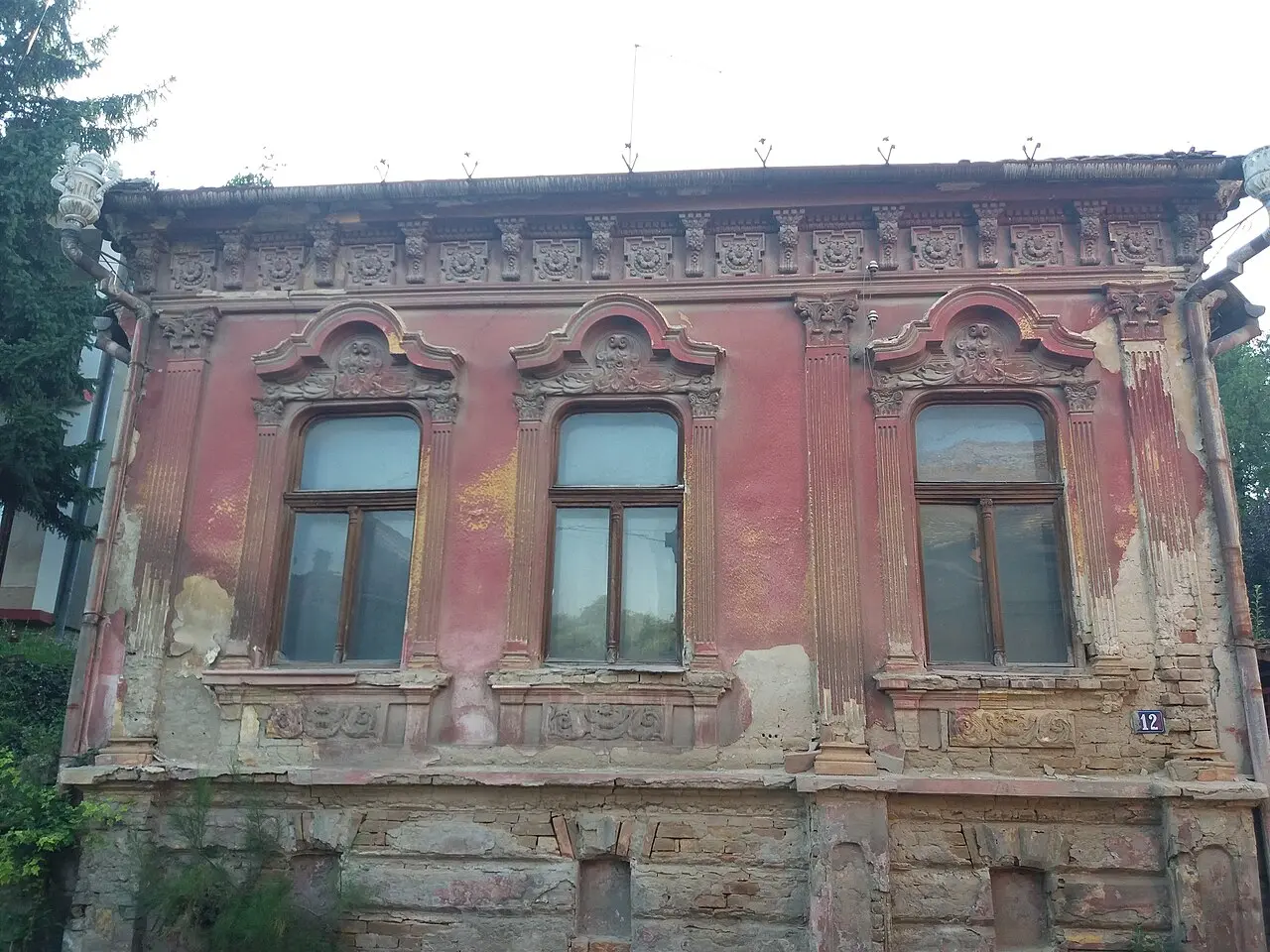 A faded pink Baroque facade with carved window frames in Sremski Karlovci