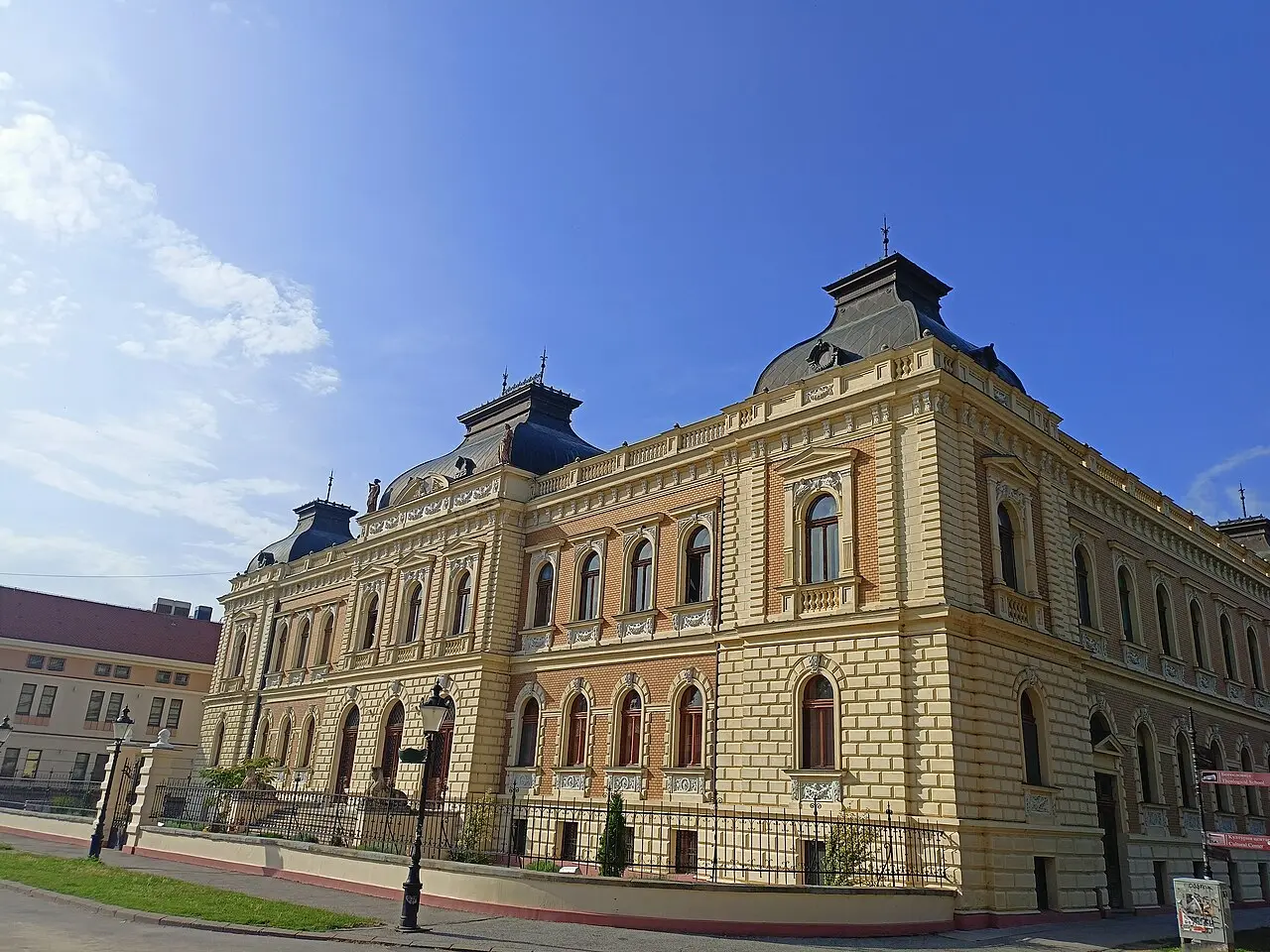 The Orthodox seminary building in Sremski Karlovci behind trees on a sunny day