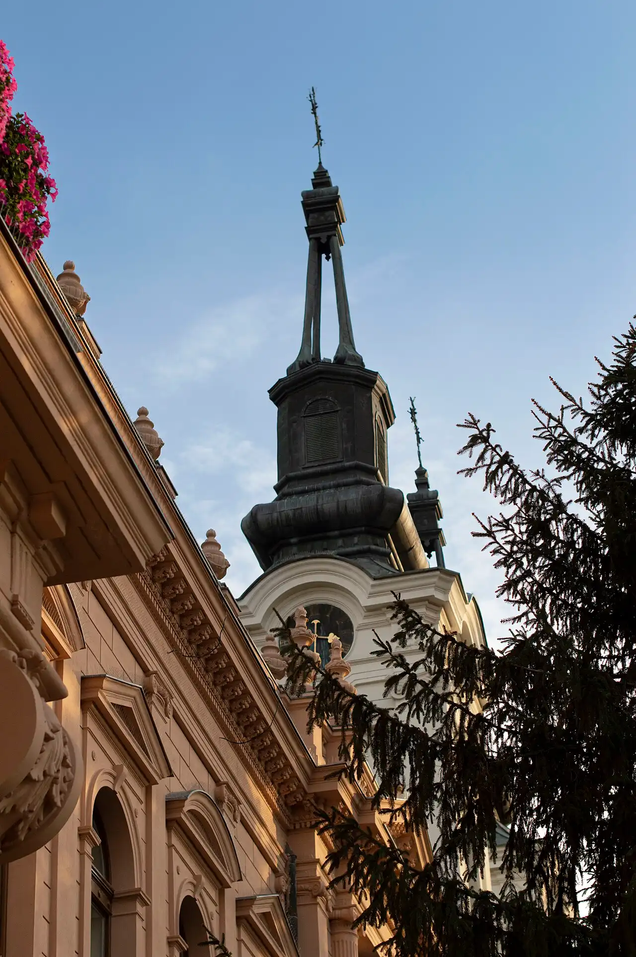 A dark spire of the cathedral in Sremski Karlovci rising above an ornamented cornice