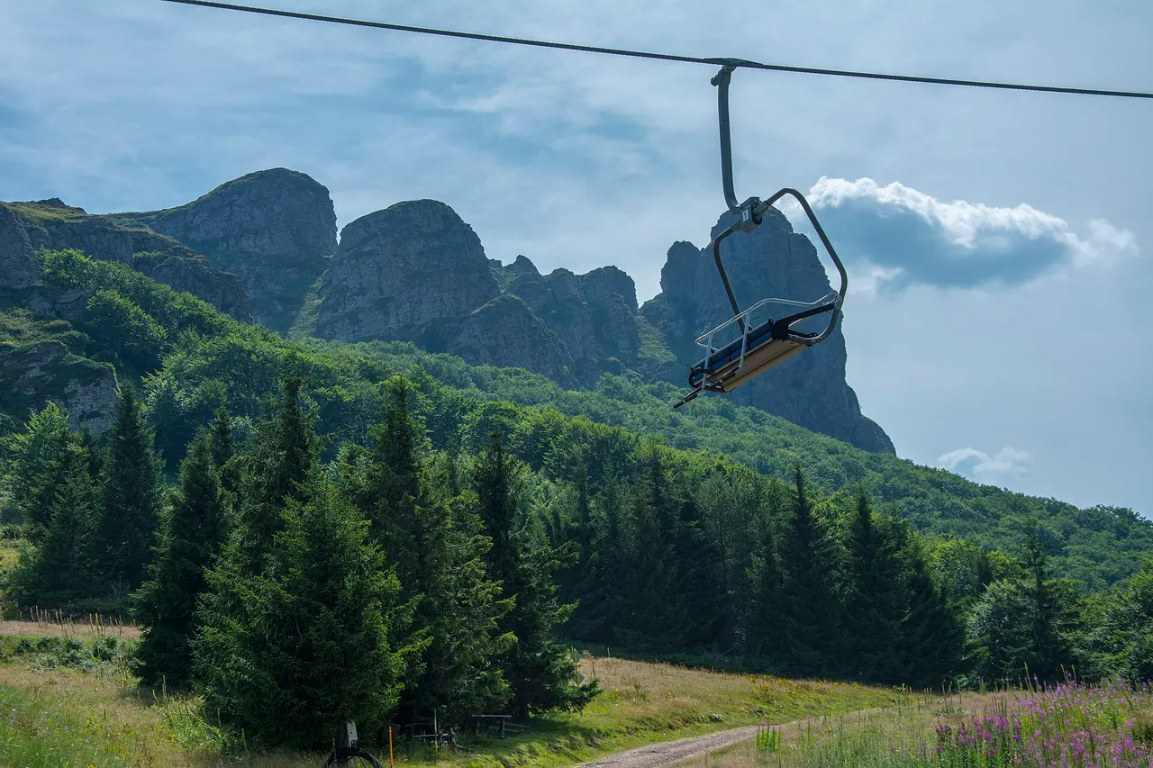 The tooth-shaped Babin Zub rock formation on Stara Planina, with a chairlift running up toward it above pine forest