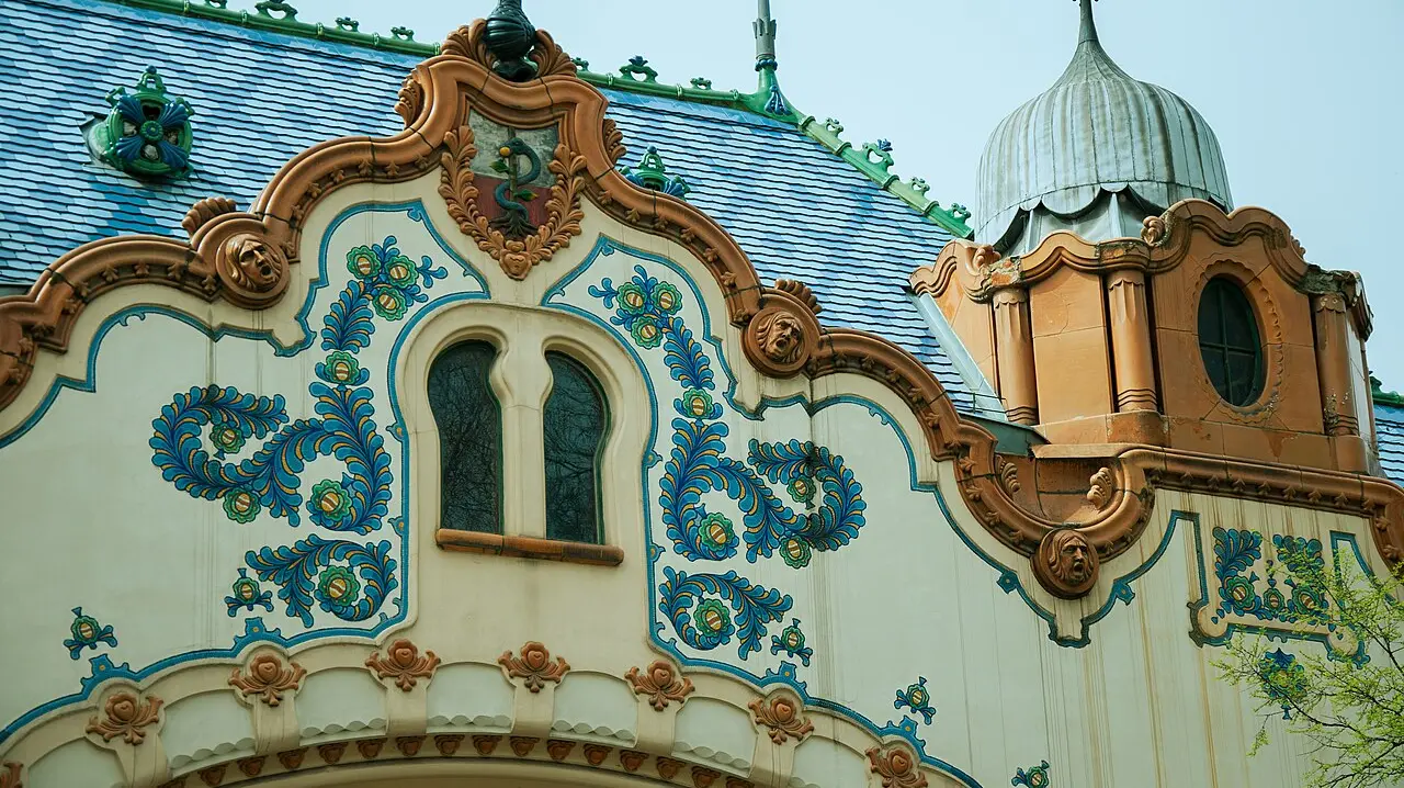 Close view of the tiled roof and floral ceramic ornament on the gable of Raichle Palace in Subotica