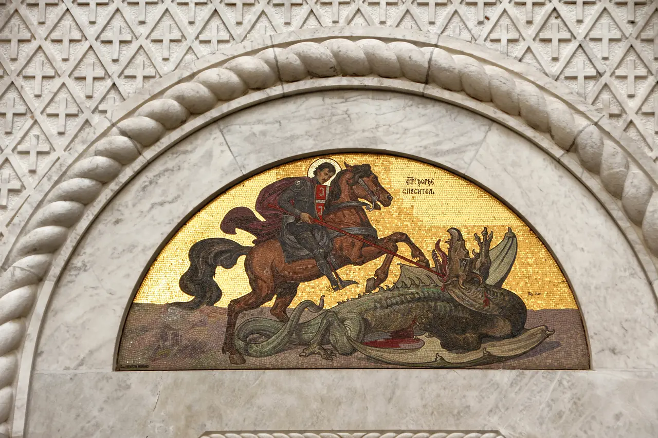 The golden mosaic of St George slaying the dragon above the church portal at Oplenac