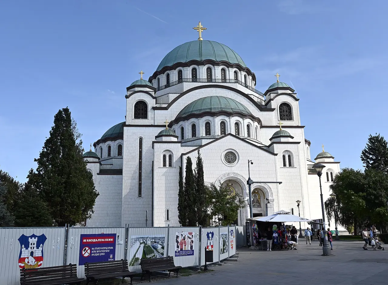 The main west entrance and bronze doors of the Temple of Saint Sava with worshippers on the steps